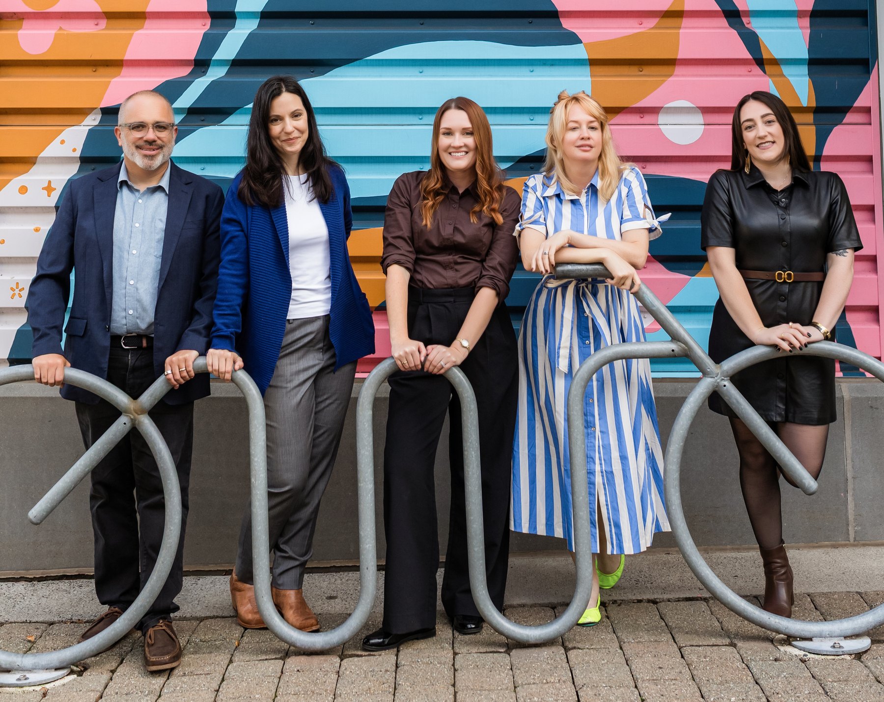 The Best Era team at a bike rack in front of a colorful mural